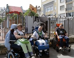 Image de 3 personnes assises dans des chaises roulantes qui ont été portaités dans l'exposition