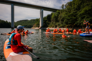 Image d'animateurs sur un stand-up paddle en train de surveiller une activité sur le lac de haute sure