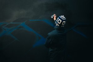 L'artiste Sare entrain de dessiner sur Le Mur du City Musée