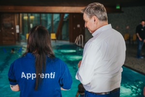 Image du Ministre Meisch en discussion avec une apprentie à la piscine de Bonnevoie