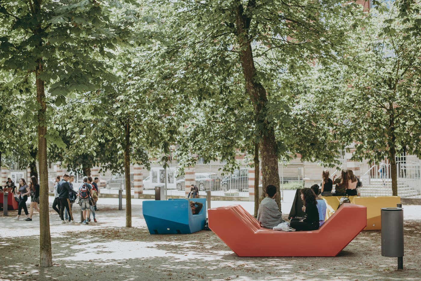 Photo des gens pendant une détente sous les arbres en ville