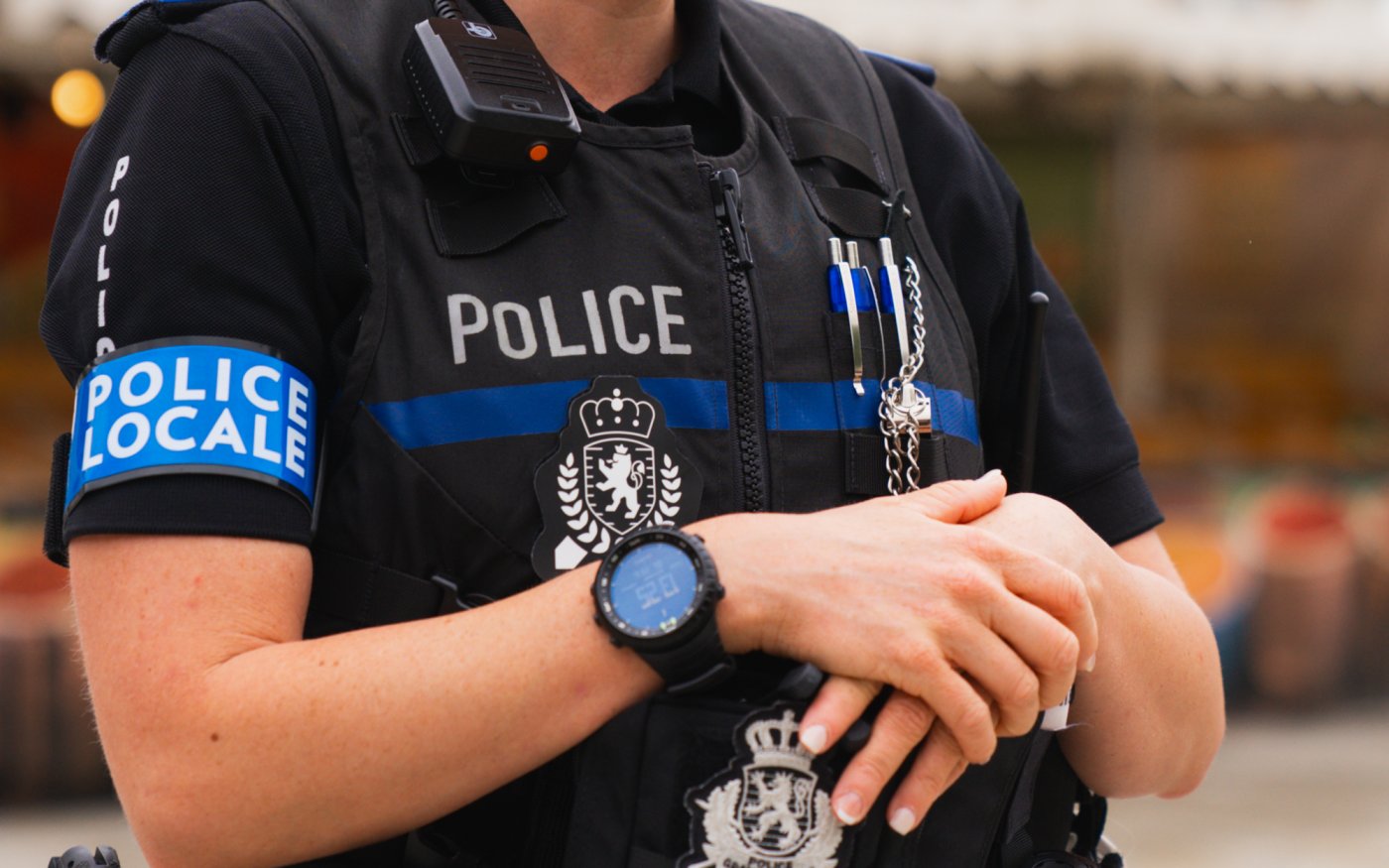 Image type "close up" d'un policier ayant un signe de "police locale" autour du bras