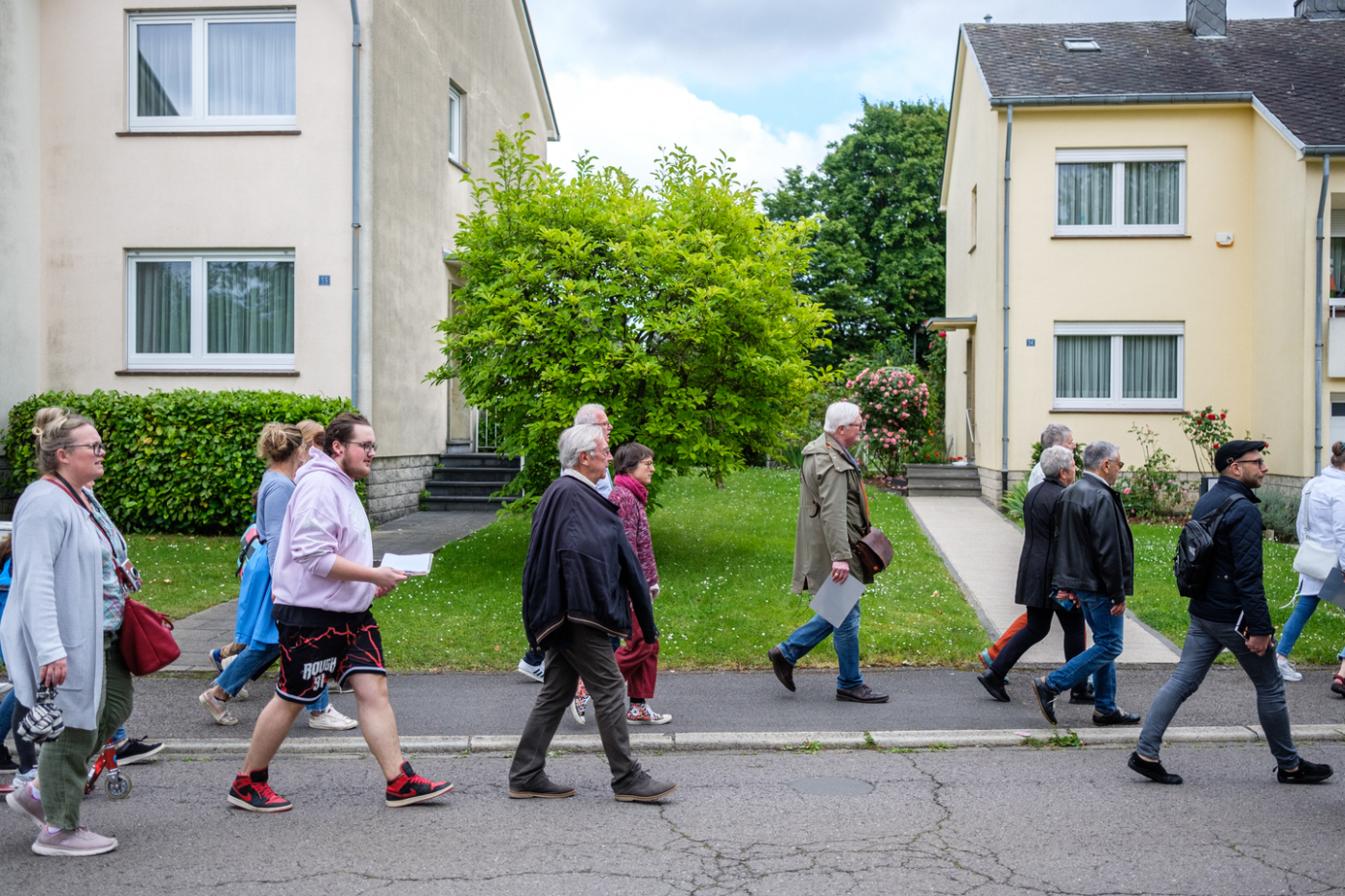 Image de personnes qui se déplacent en groupe dans le quartier Cents