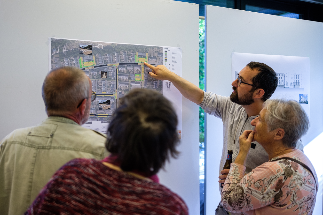 Image de personnes regardant le plan d'une rue sur un whiteboard.