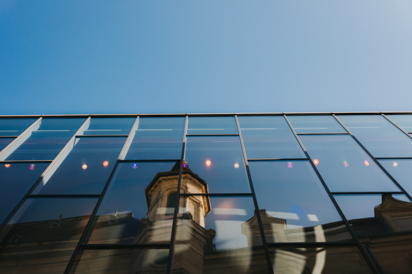 Image de la réflection du Cercle Cité dans la façade en verre de la City Bibliothèque