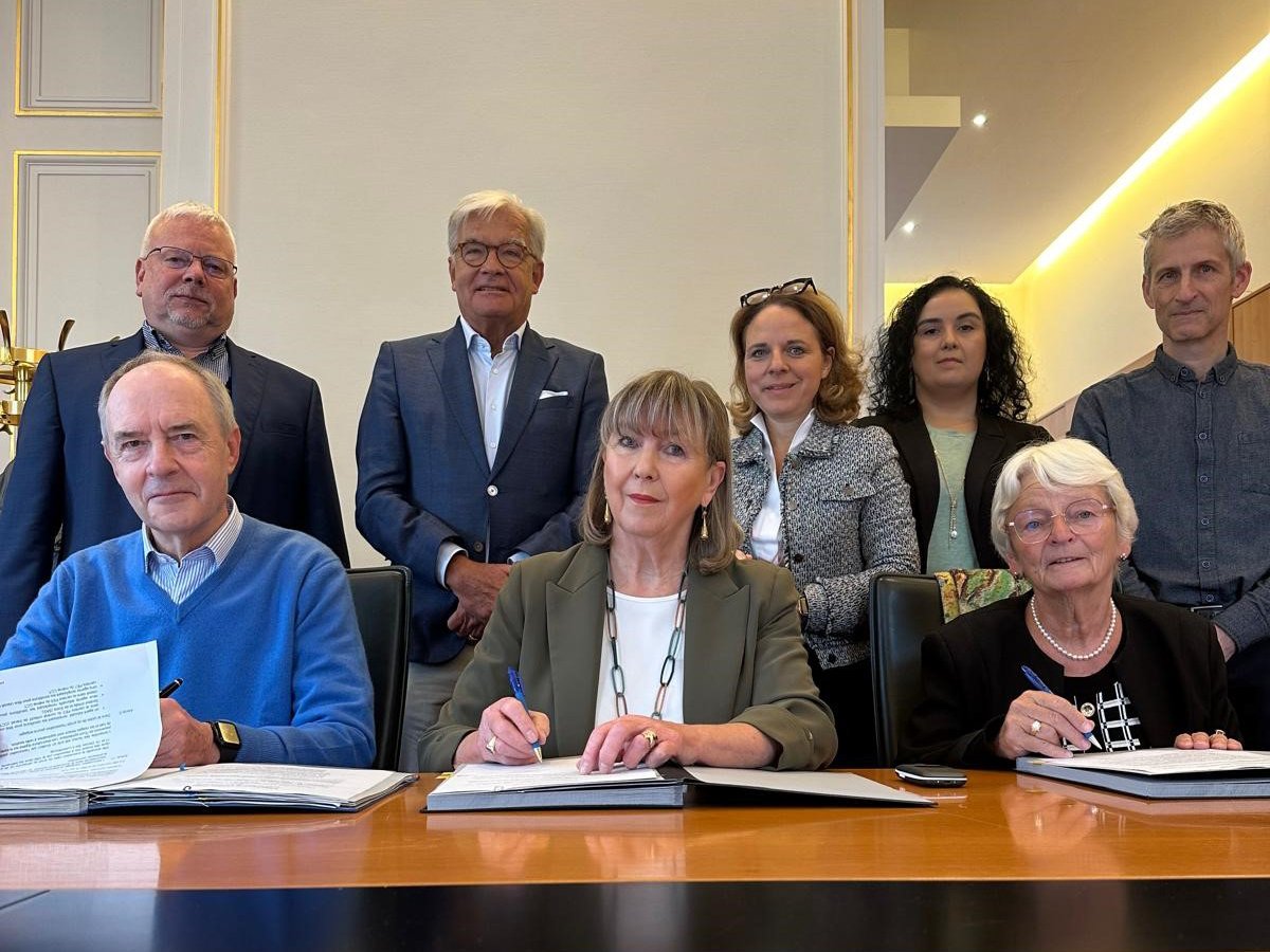 Image des responsables politiques en train de signer le contrat ensemble avec Madame Marie-Josée Jacobs de la Caritas