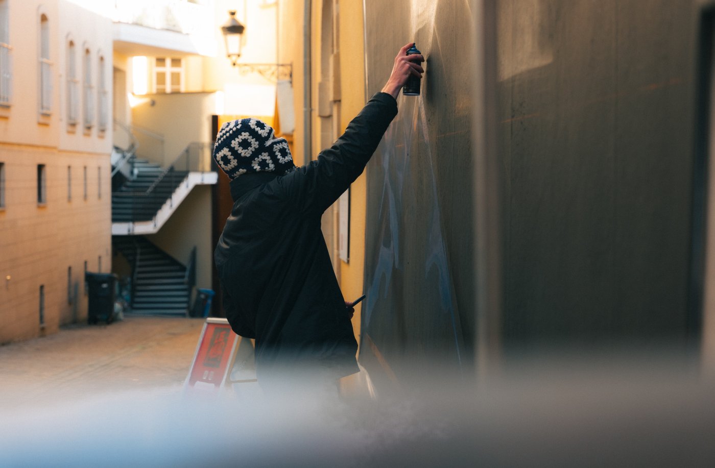 L'artiste Sare entrain de dessiner sur Le Mur du City Musée