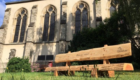 banc en bois devant une église fabriqué dans les ateliers du patrimoine naturel