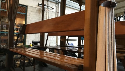 sièges en bois d'une carrosse au musée des tramways