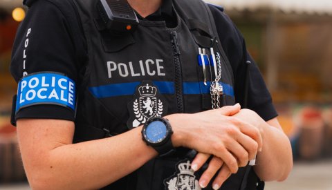 Image type "close up" d'un policier ayant un signe de "police locale" autour du bras