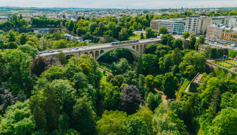 Image de pris par un drone donnant vue sur le Pont Adolphe enveloppé dans de la verdure lors du mois de juin.